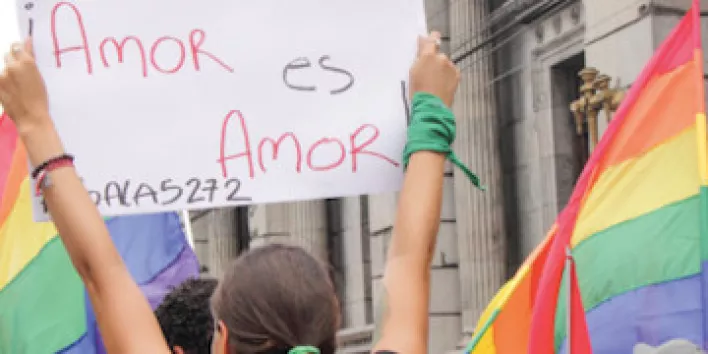 Person hält ein Schild mit der Aufschrift "Amor es Amor"